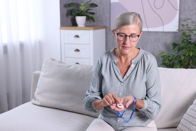 Senior woman pressing emergency call button at home