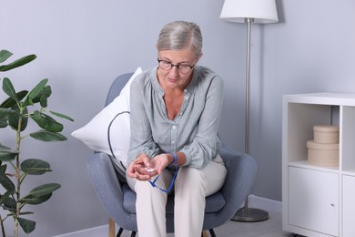 Senior woman pressing emergency call button at home