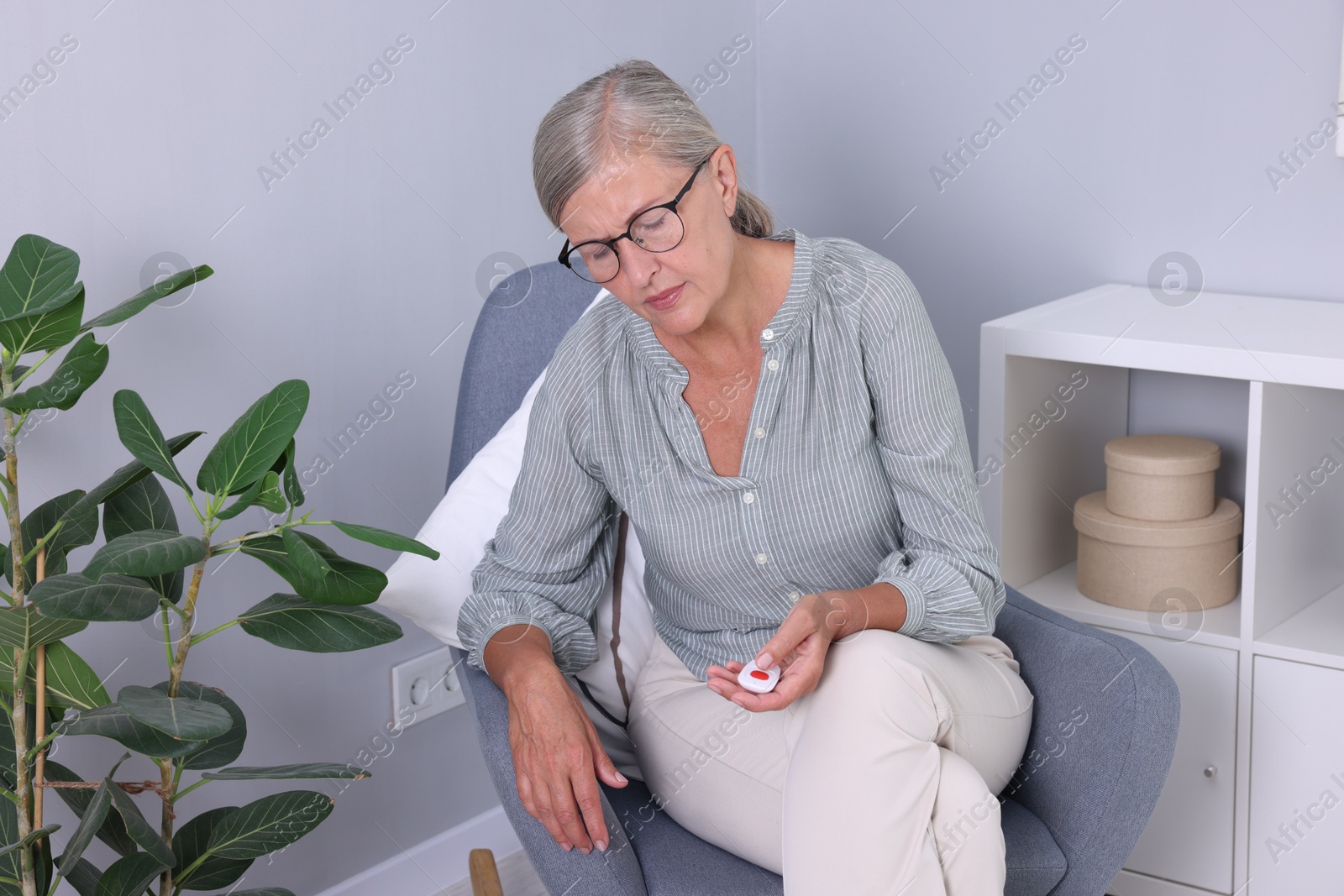 Photo of Senior woman with emergency call button at home