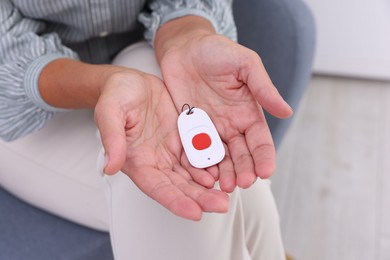 Photo of Senior woman with emergency call button at home, closeup