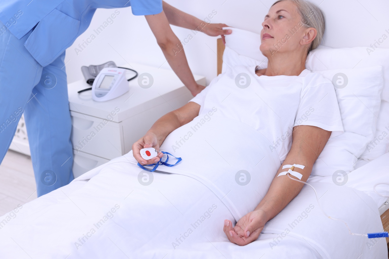 Photo of Senior woman with emergency call button and nurse in hospital