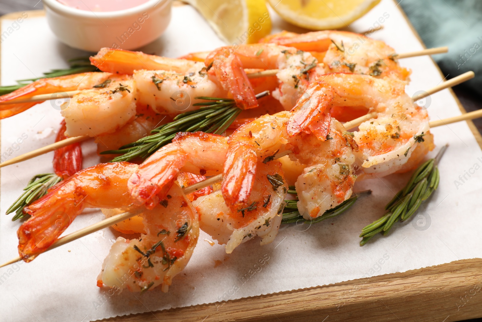 Photo of Skewers with delicious grilled shrimps on table, closeup