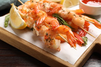 Photo of Skewers with delicious grilled shrimps on table, closeup