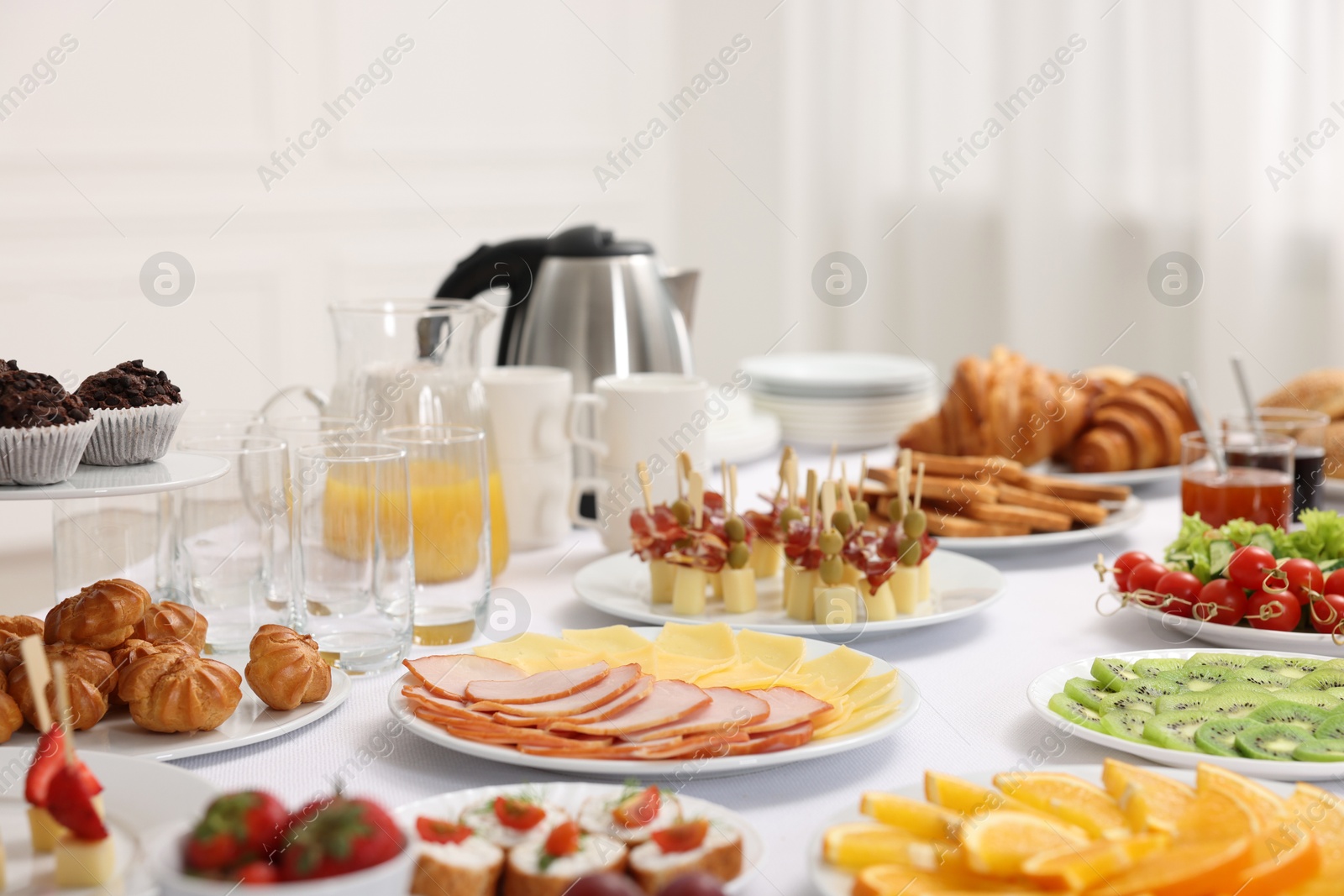 Photo of Different meals served on white table indoors. Buffet menu