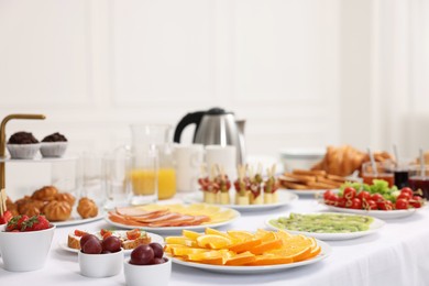 Different meals served on white table indoors. Buffet menu