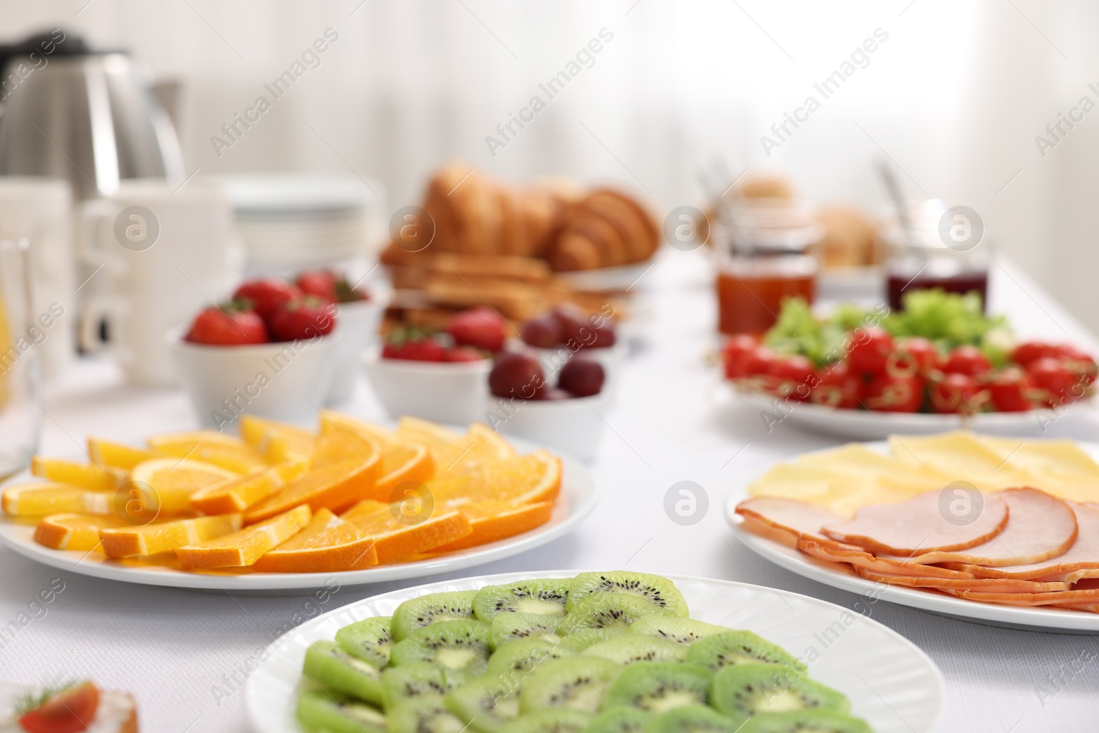 Photo of Different meals served on white table indoors, closeup. Buffet menu