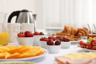 Different meals served on white table indoors, selective focus. Buffet menu