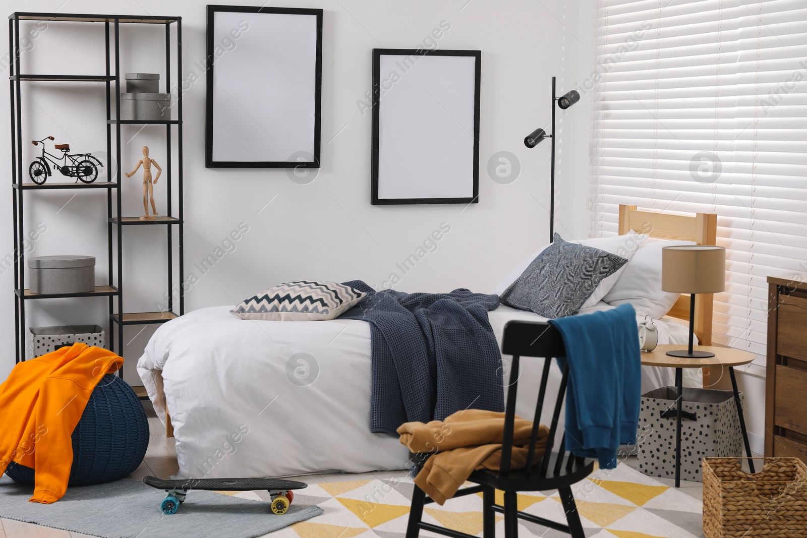 Photo of Teen's room interior with modern furniture and empty frames on wall