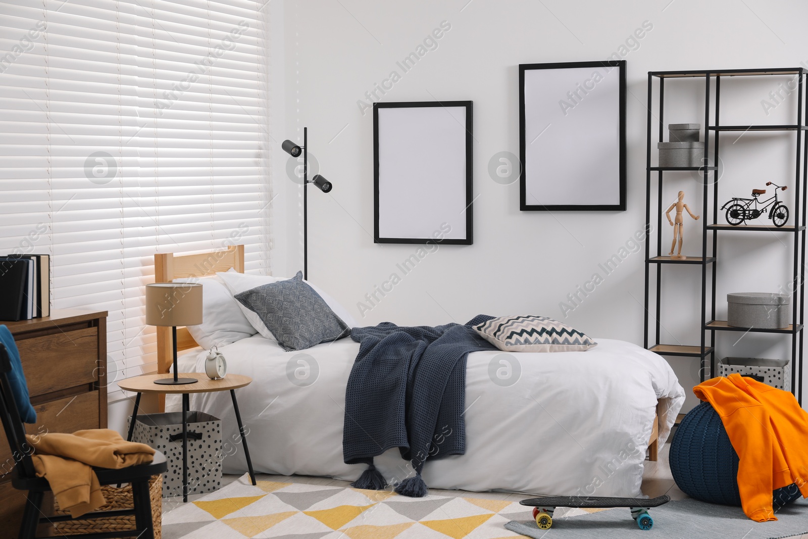 Photo of Teen's room interior with modern furniture and empty frames on wall