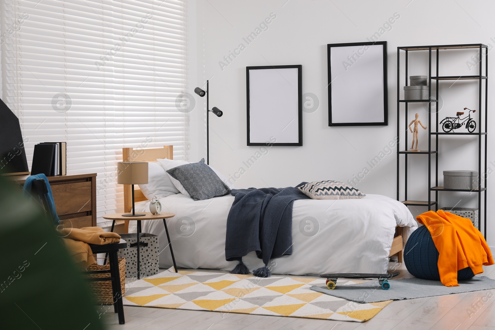 Photo of Teen's room interior with modern furniture and empty frames on wall