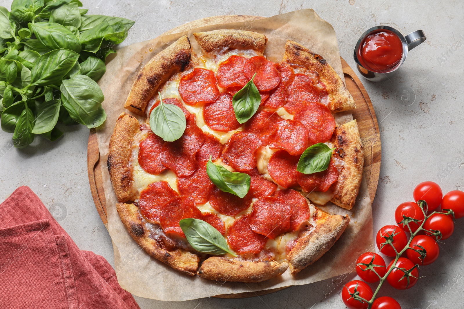 Photo of Tasty pepperoni pizza with basil, tomatoes and sauce on light grey table, top view