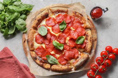 Photo of Tasty pepperoni pizza with basil, tomatoes and sauce on light grey table, top view