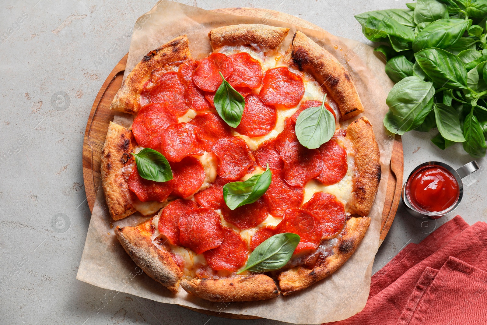 Photo of Tasty pepperoni pizza with basil and sauce on light grey table, top view