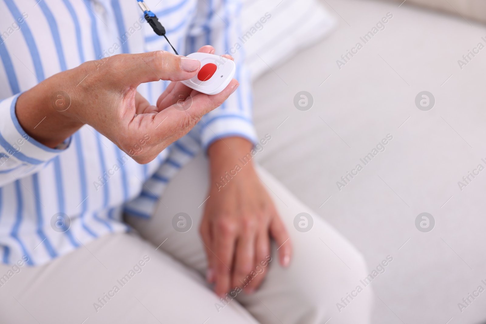 Photo of Senior woman pressing emergency call button at home, closeup. Space for text