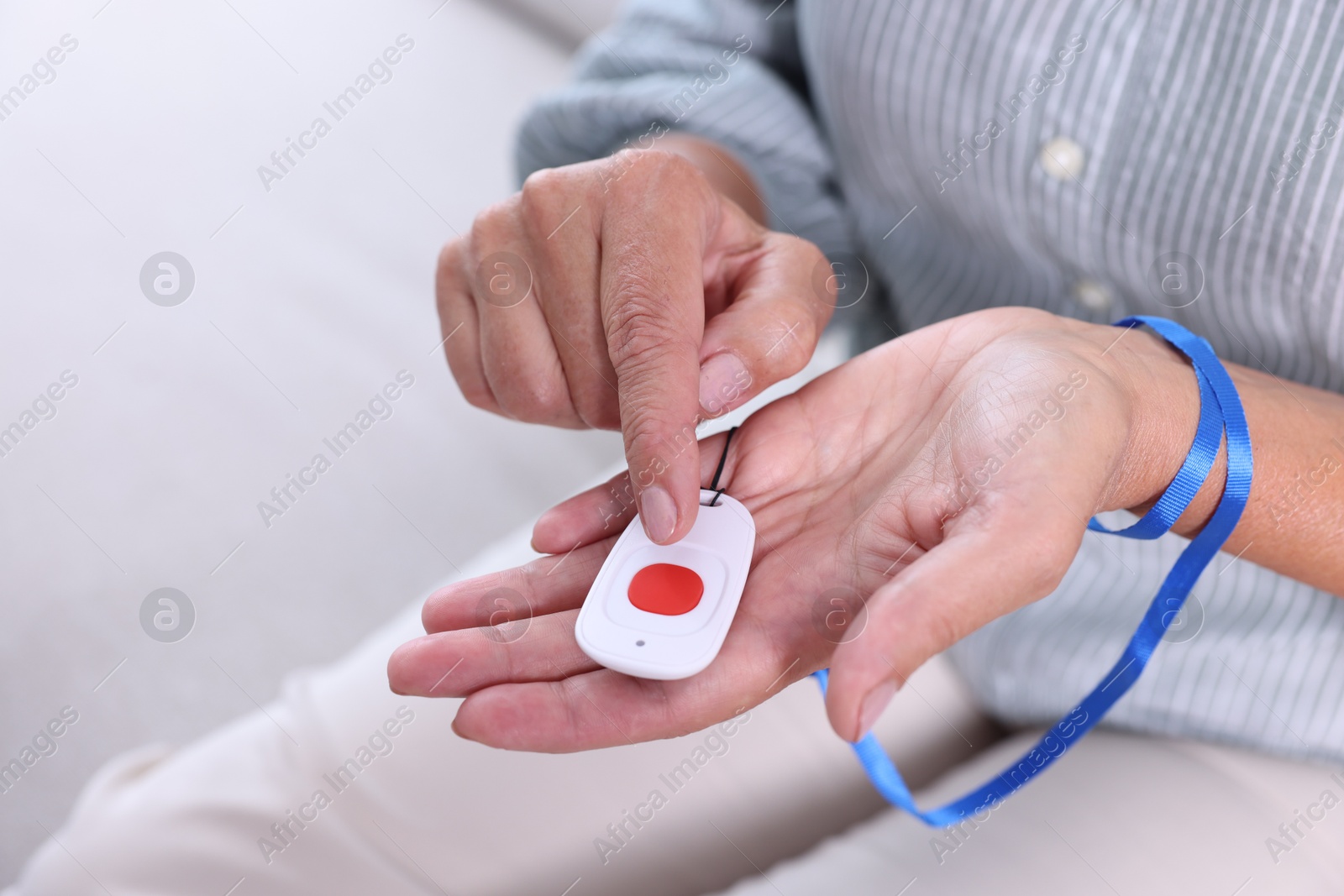 Photo of Senior woman pressing emergency call button at home, closeup