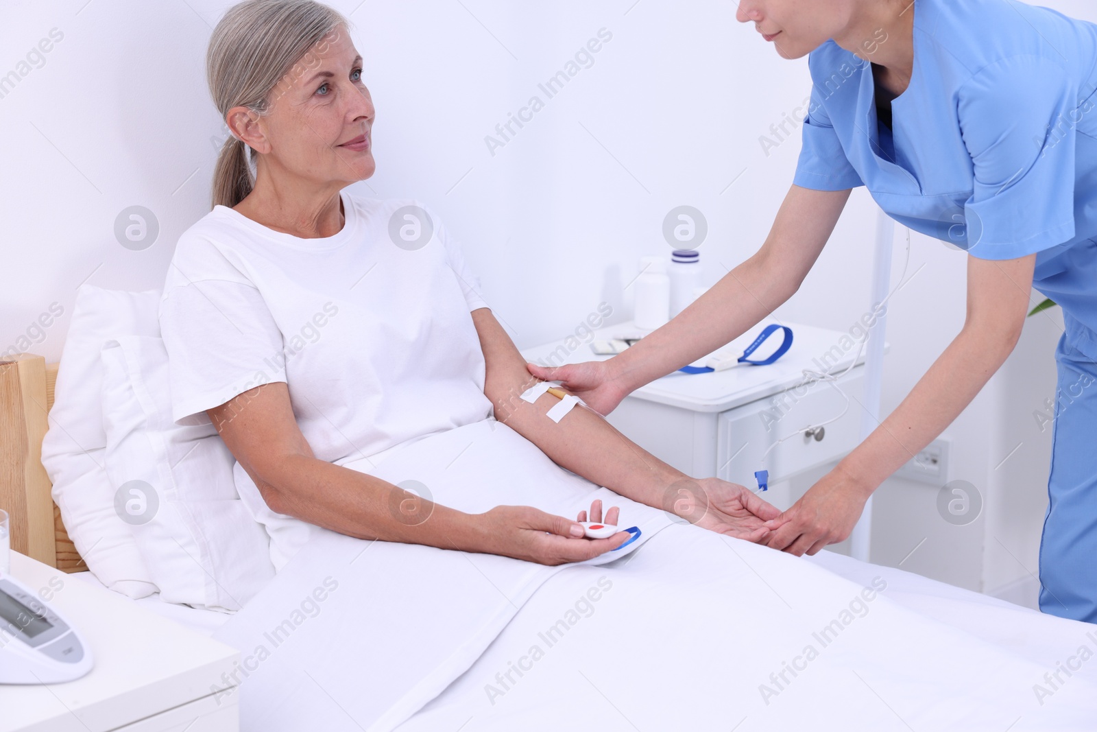 Photo of Senior woman with emergency call button and nurse in hospital