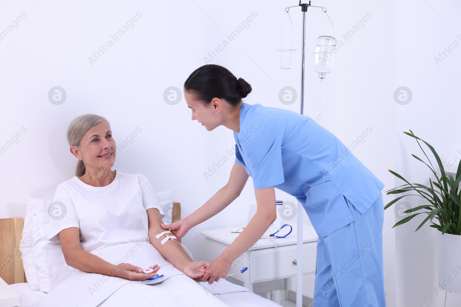 Photo of Senior woman with emergency call button and nurse in hospital