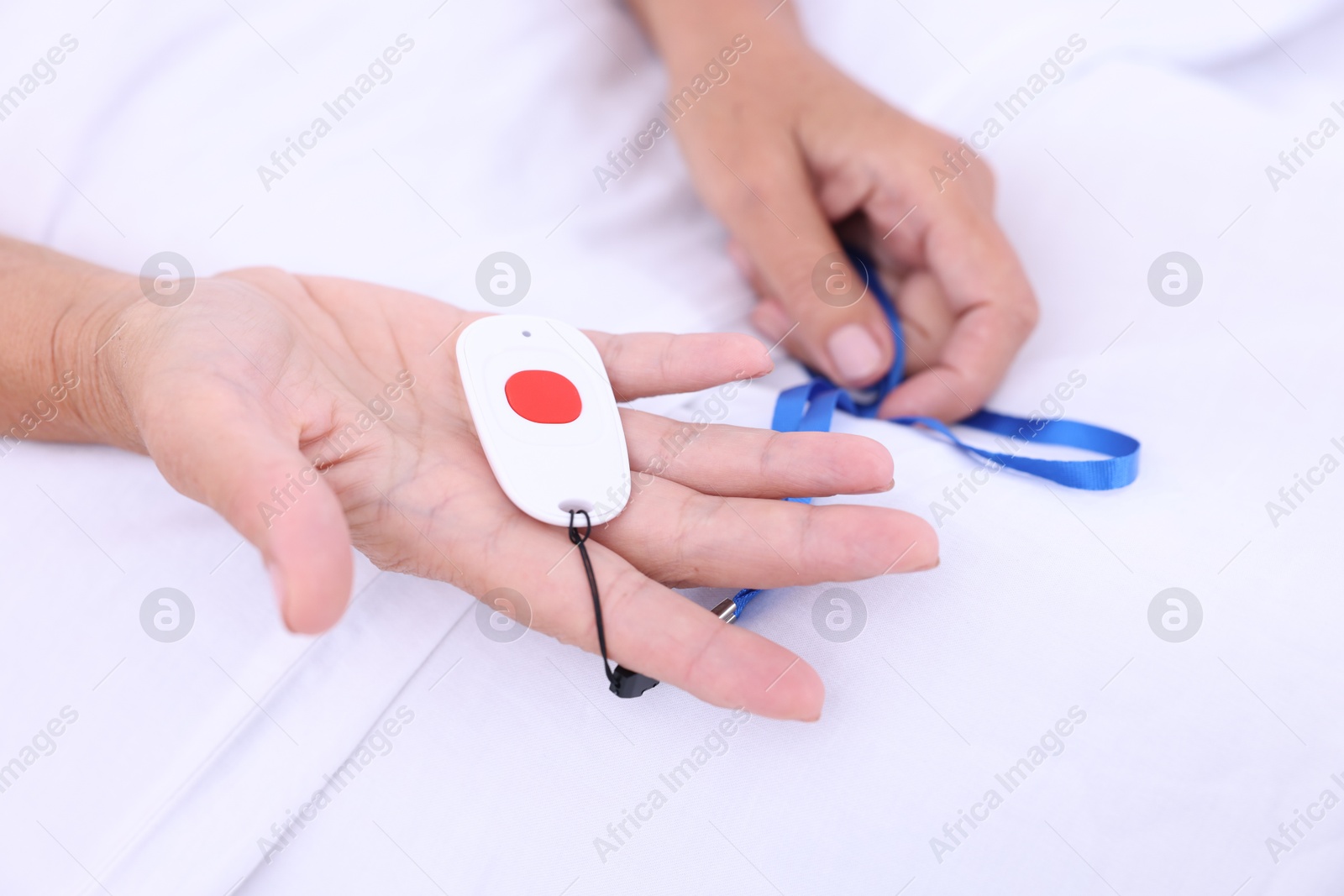 Photo of Senior woman with emergency call button on bed in hospital, closeup