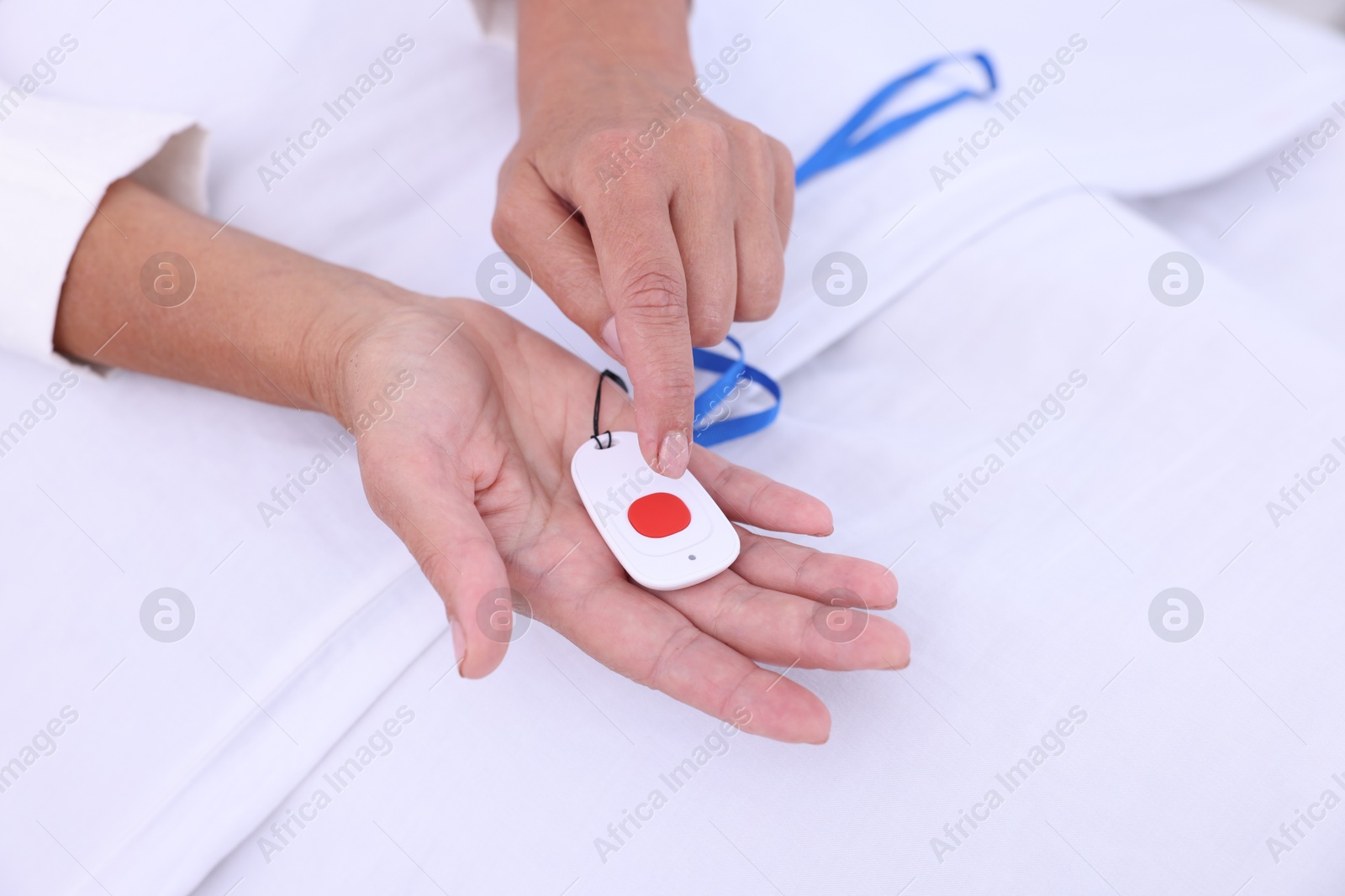 Photo of Senior woman with emergency call button on bed in hospital, closeup