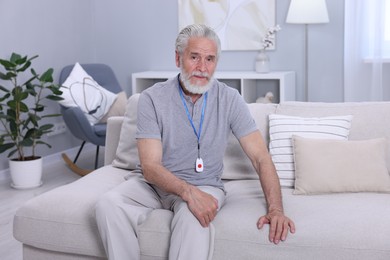 Photo of Senior man with emergency call button at home