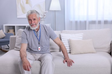 Senior man with emergency call button at home