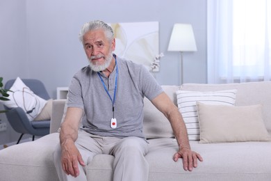 Senior man with emergency call button at home