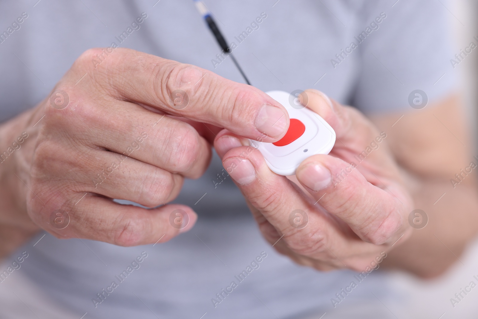 Photo of Senior man with emergency call button, closeup