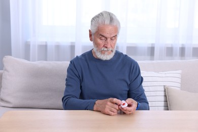 Senior man pressing emergency call button at home