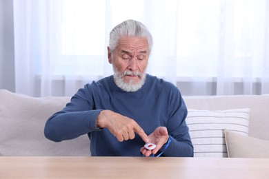 Senior man pressing emergency call button at home