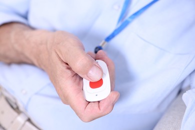 Photo of Senior man pressing emergency call button, closeup