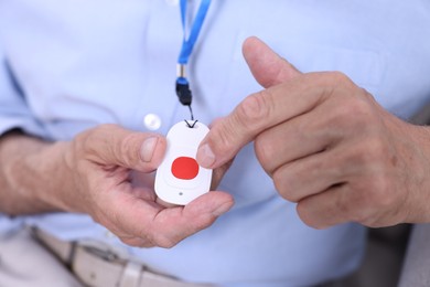 Photo of Senior man with emergency call button, closeup