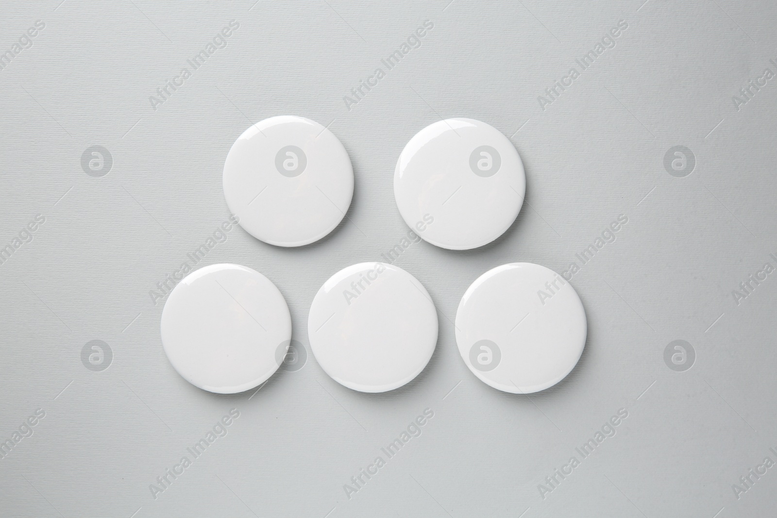 Photo of Blank white button badges on grey background, top view. Mockup for design