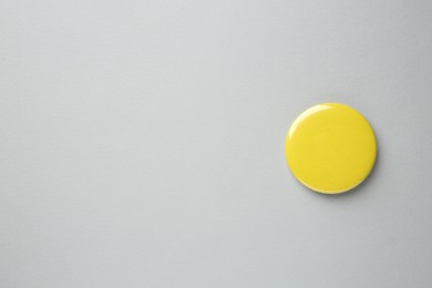 Photo of Blank yellow button badge on grey background, top view and space for text. Mockup for design