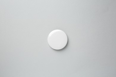 Photo of Blank white button badge on grey background, top view. Mockup for design