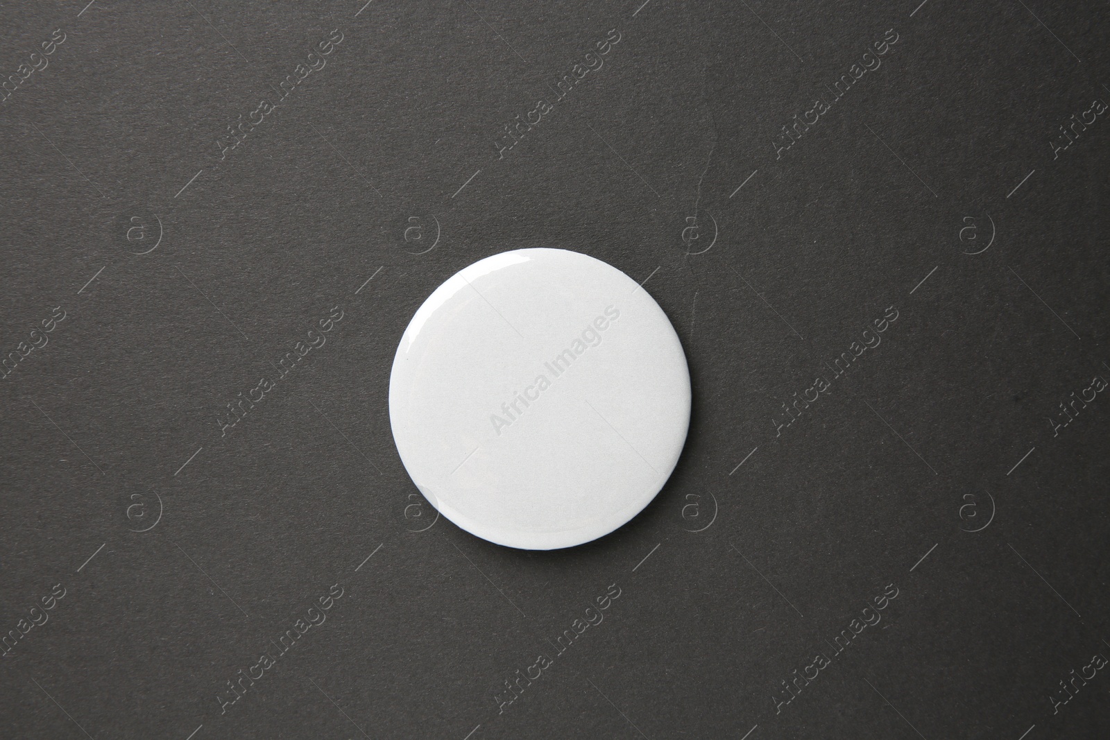 Photo of Blank white button badge on black background, top view. Mockup for design