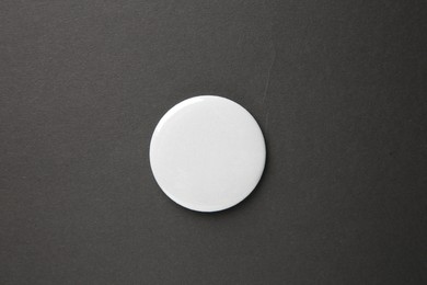 Blank white button badge on black background, top view. Mockup for design