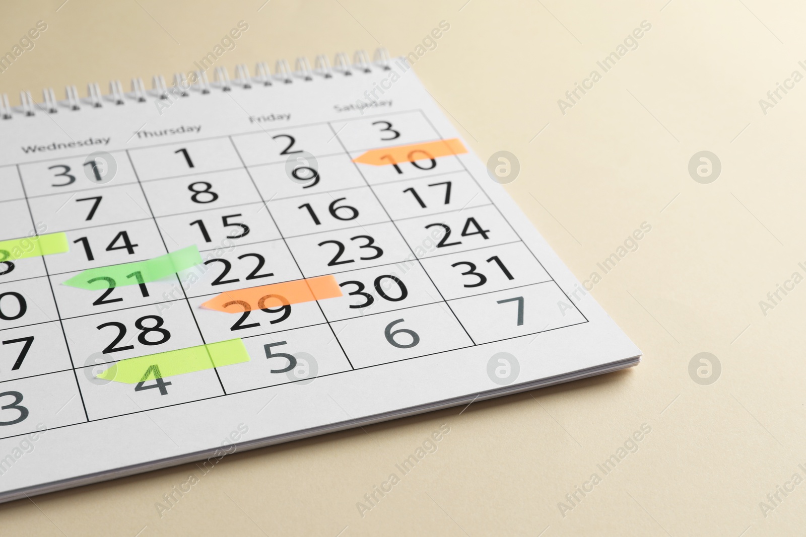 Photo of Timetable. Calendar page with colorful sticky notes on beige background