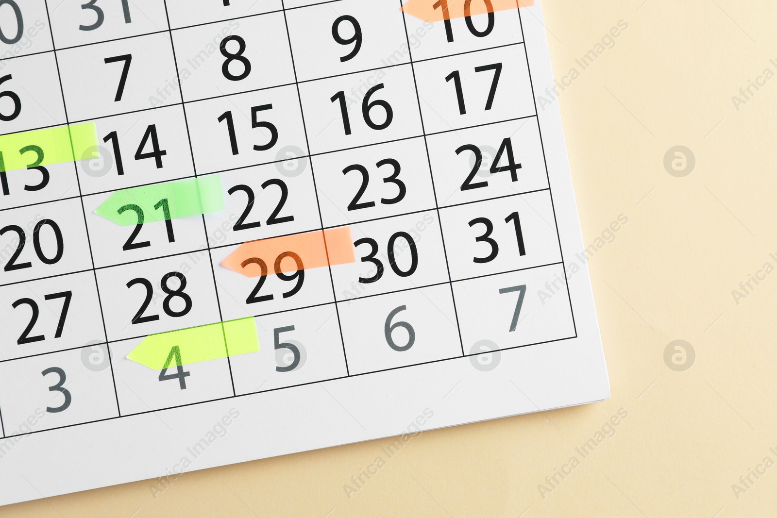 Photo of Timetable. Calendar page with colorful sticky notes on beige background, top view