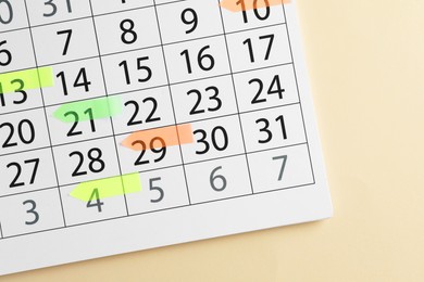 Photo of Timetable. Calendar page with colorful sticky notes on beige background, top view