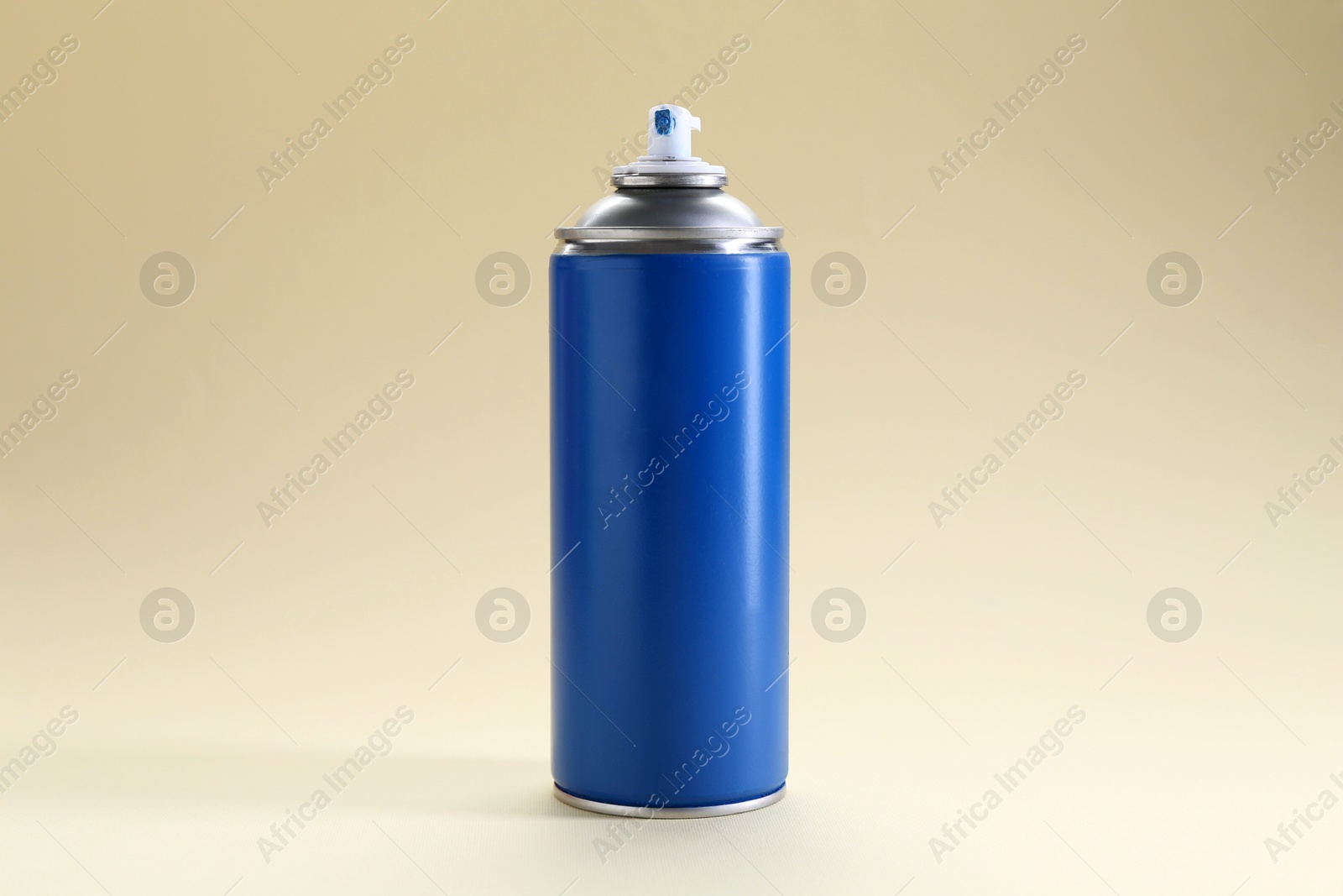 Photo of Blue spray paint can on beige background