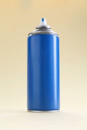 Photo of Blue spray paint can on beige background