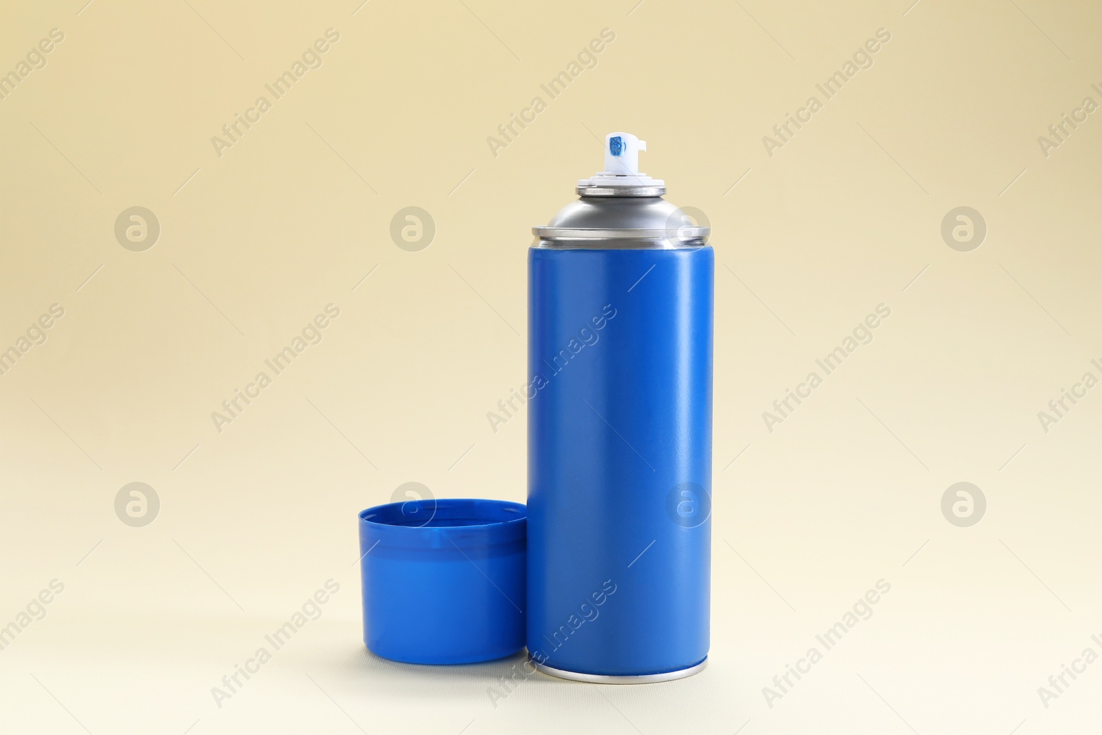 Photo of Blue spray paint can on beige background