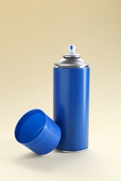 Photo of Blue spray paint can on beige background