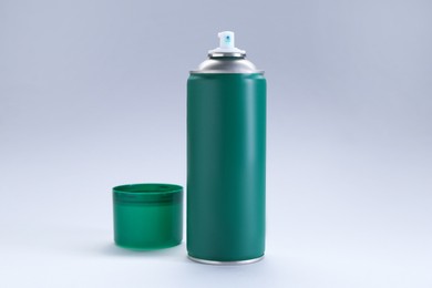 Green spray paint can on gray background