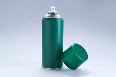 Green spray paint can on gray background