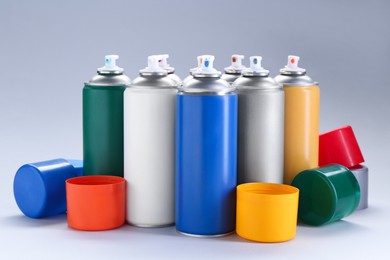 Many spray paint cans on gray background