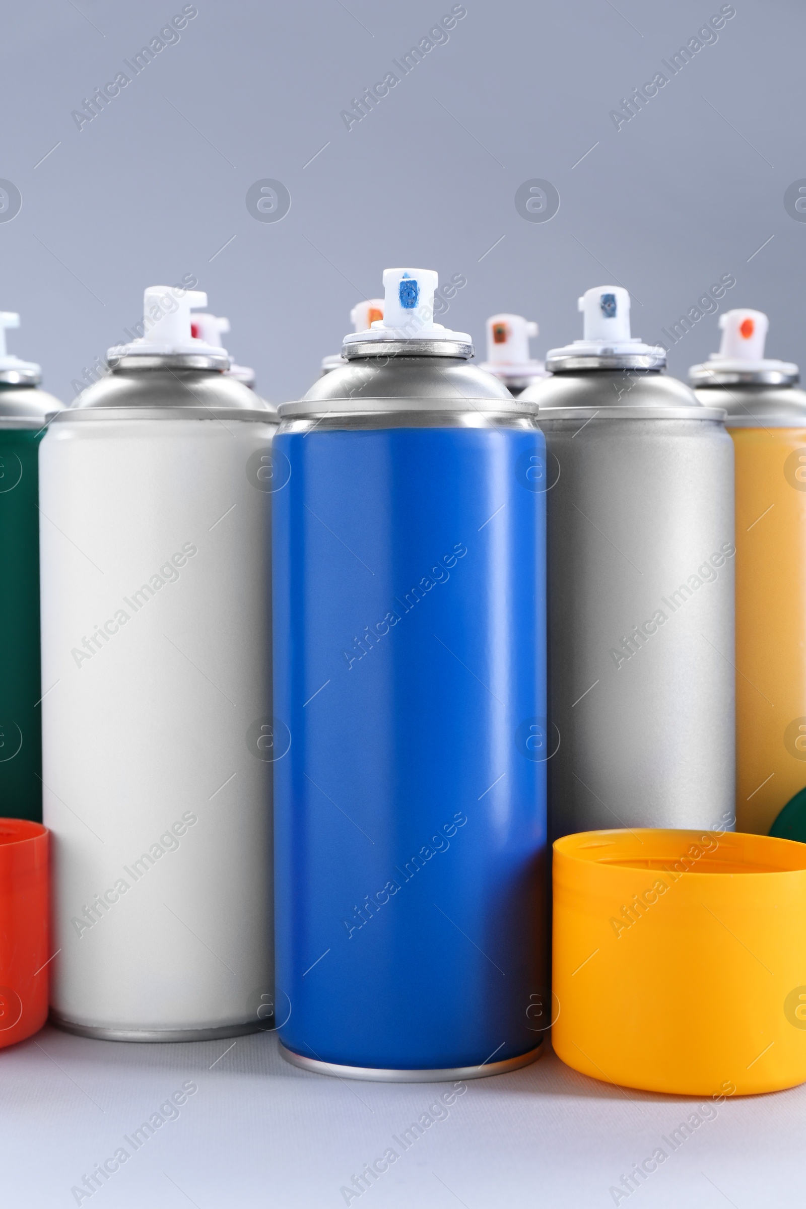 Photo of Many spray paint cans on gray background