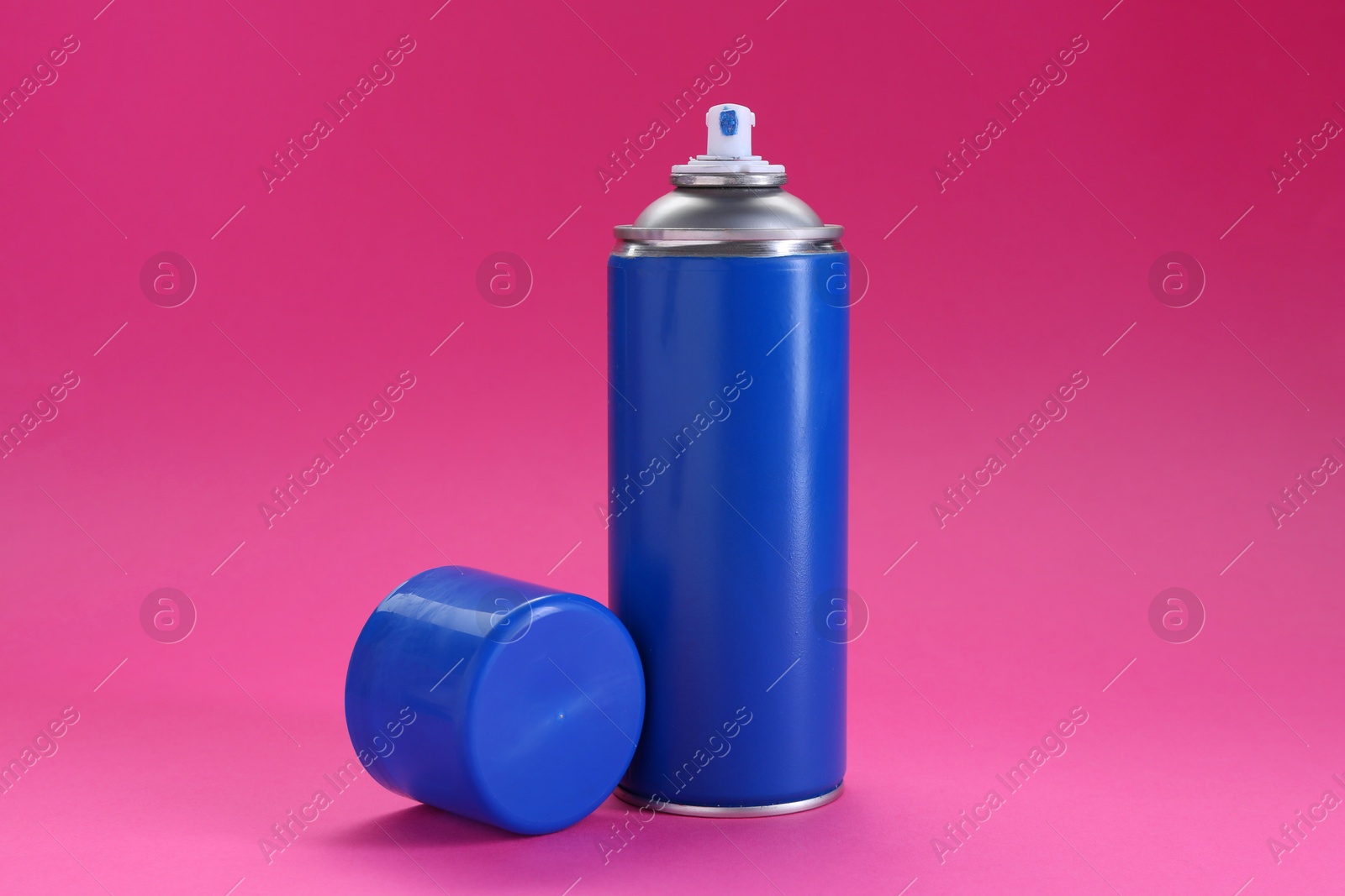 Photo of Blue spray paint can on pink background