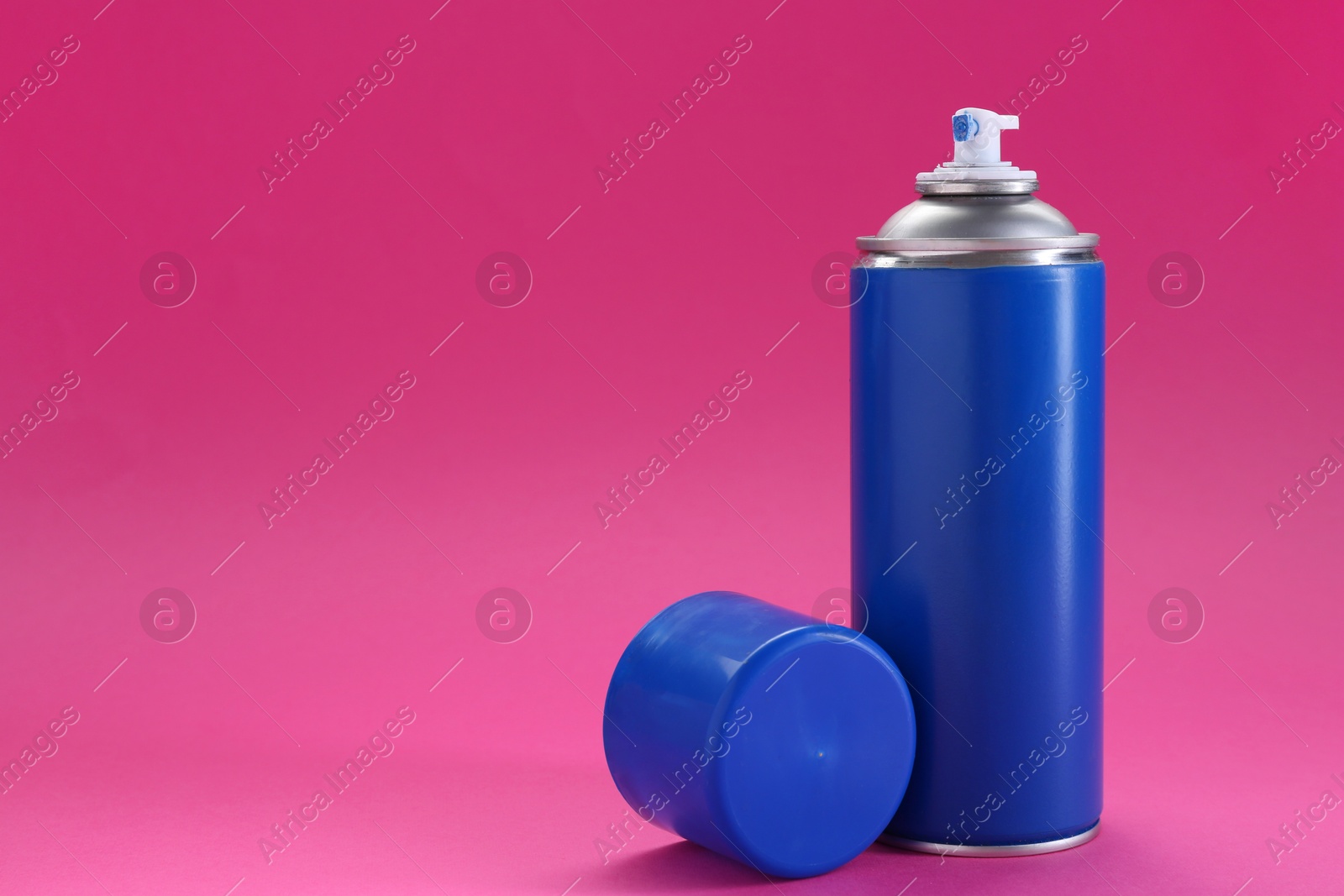 Photo of Blue spray paint can on pink background, space for text