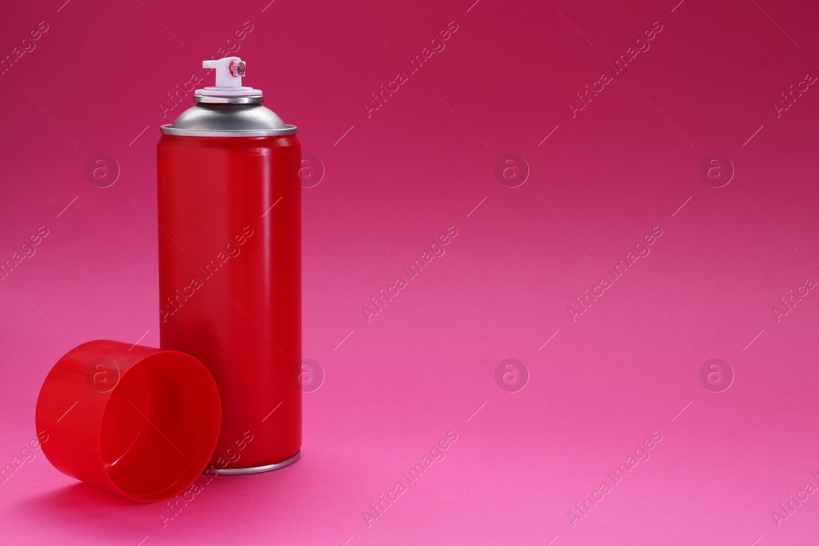 Photo of Red spray paint can on pink background, space for text